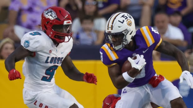 LSU Tigers wide receiver Malik Nabers (8) catchers a pass against New Mexico Lobos cornerback A.J. Odums (4) and safety Jerrick Reed II (9) during the first half at Tiger Stadium.